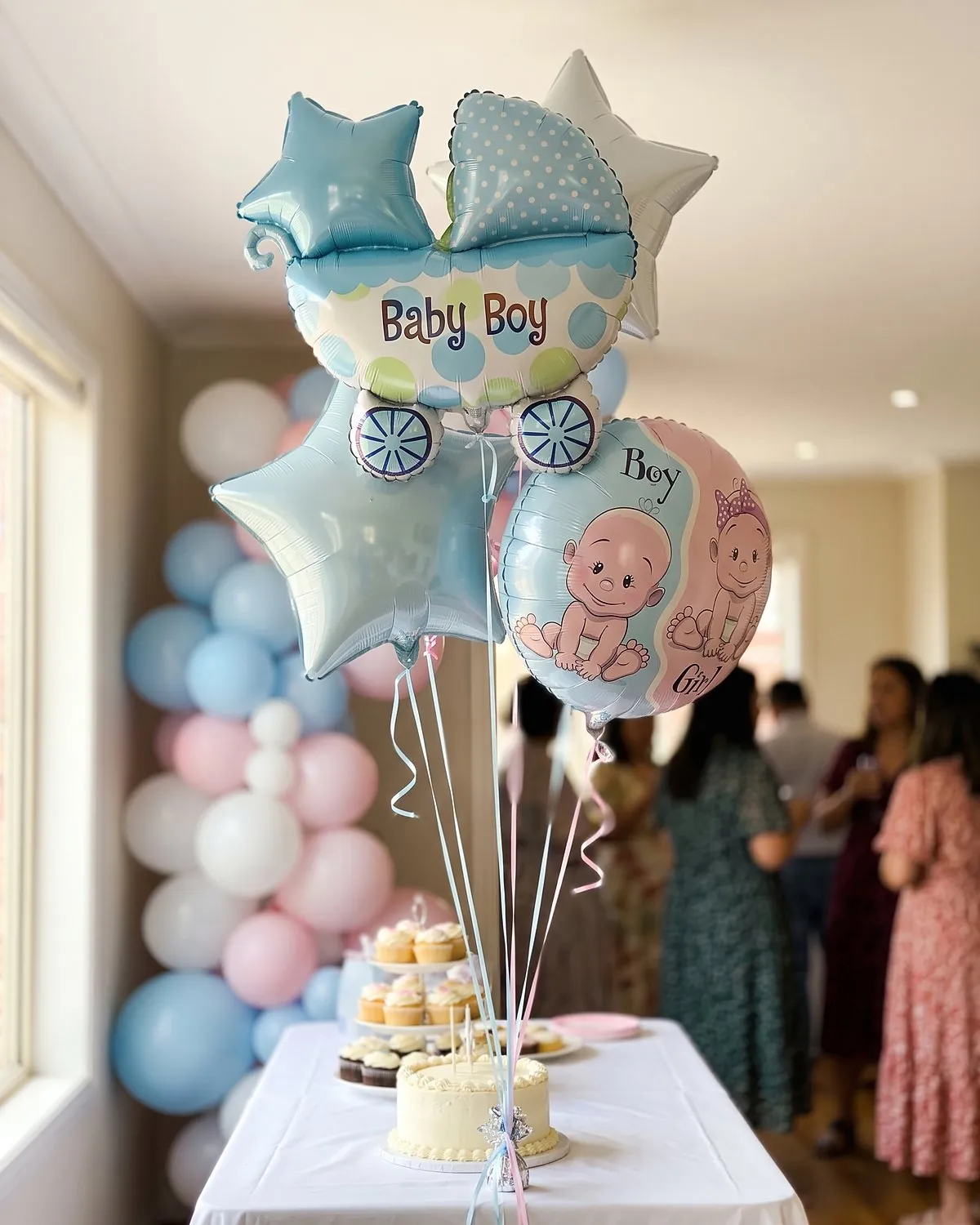 Ballons Baby Boy et Boy or Girl au-dessus d'une table de baby shower